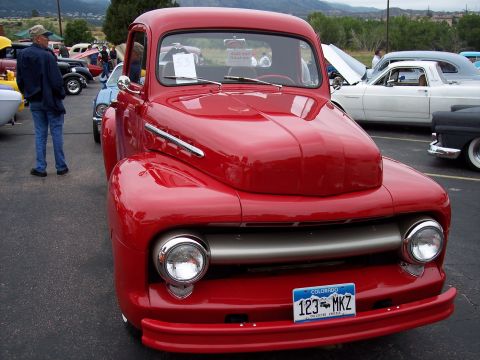 1972 Ford Ranchero - A red pickup truck is parked at an outdoor event with other vehicles visible.
