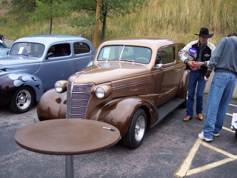 1972 Ford Ranchero - A vintage brown sedan with a distinctive grille is parked at an outdoor event.