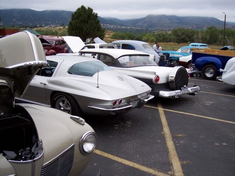 1972 Ford Ranchero - Several classic cars, including a C2 Corvette, are parked outdoors with mountains in the distance.