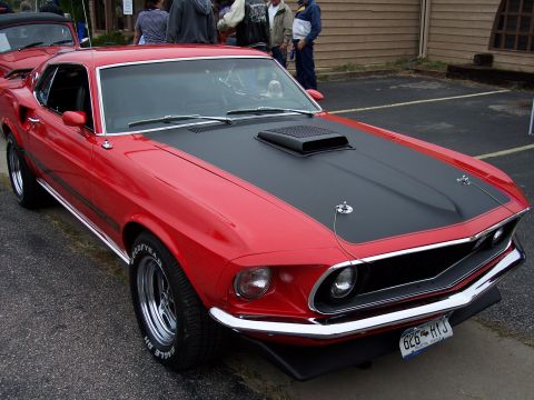 1972 Ford Ranchero - This red 1969 Ford Mustang Mach 1 features a distinctive black hood scoop and racing stripes.