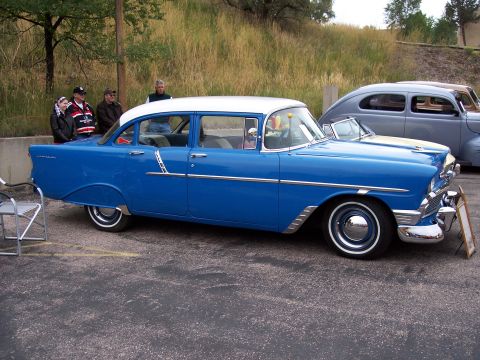 1972 Ford Ranchero - A blue and white sedan is parked outdoors next to another vehicle.