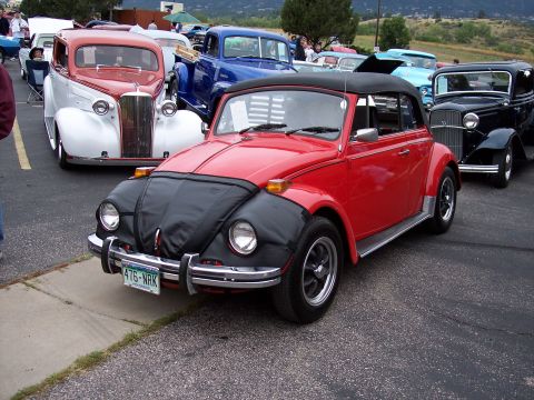 1972 Ford Ranchero - A red convertible Volkswagen Beetle is parked among other vintage vehicles at an outdoor event.