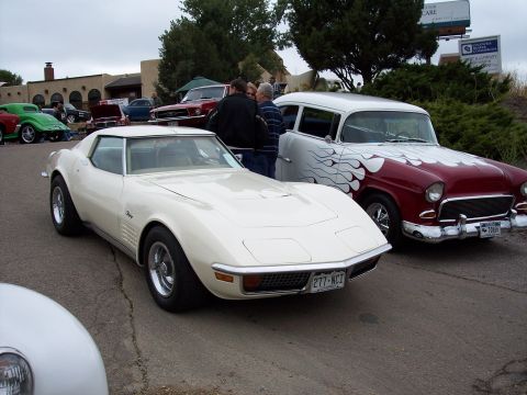 1972 Ford Ranchero - A white 1975 Chevrolet Corvette Stingray is parked next to a classic car with flame graphics.