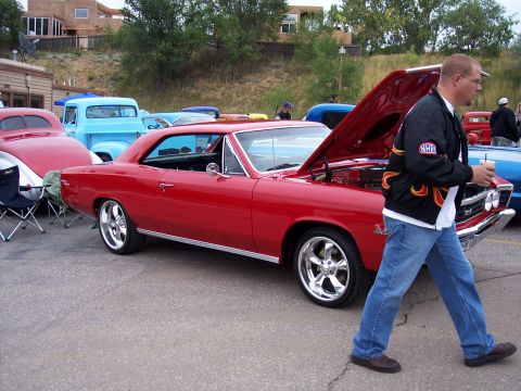 1972 Ford Ranchero - A red 1967 Chevrolet Chevelle coupe is displayed with its hood open at an outdoor event.