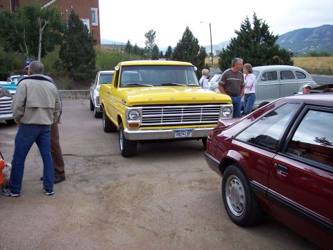 1972 Ford Ranchero - A yellow 1969 Ford pickup truck is parked in front of other vehicles.