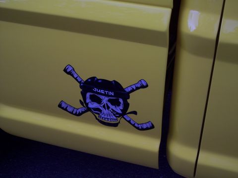 1972 Ford Ranchero - A yellow truck features a custom sticker of a skull with hockey sticks.