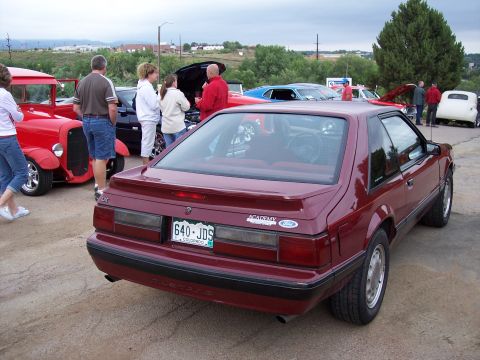 1972 Ford Ranchero - A red coupe with a spoiler and 'Academy' decal is parked at an outdoor event.