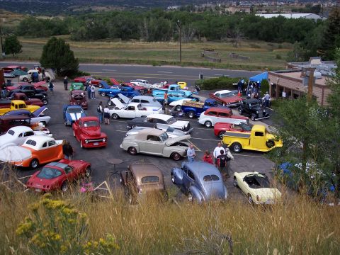 1972 Ford Ranchero - A gathering of vintage automobiles is displayed in an outdoor lot, with spectators observing the vehicles.