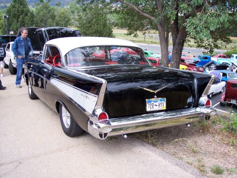 1972 Ford Ranchero - A classic black 1957 Chevrolet Bel Air with a white roof is displayed at an outdoor car show.