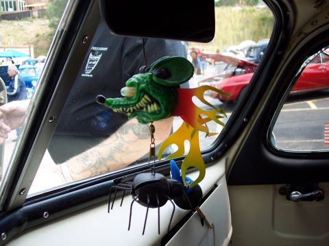 1972 Ford Ranchero - A car's interior is decorated with a green rat ornament and a spider, with other vehicles seen through the window.