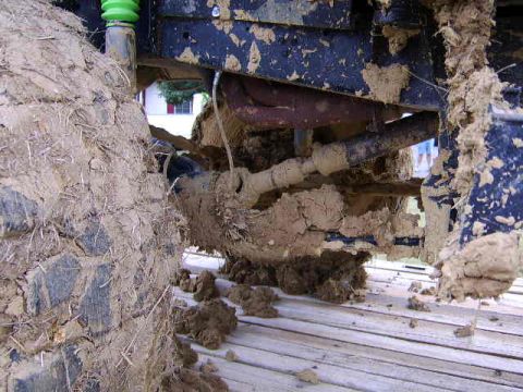 1986 Ford Ranger - The underside of a vehicle is covered in thick mud after off-roading.