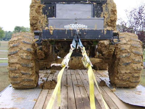 1986 Ford Ranger - This heavily mud-caked truck is being transported on a trailer, obscuring its make and model details.