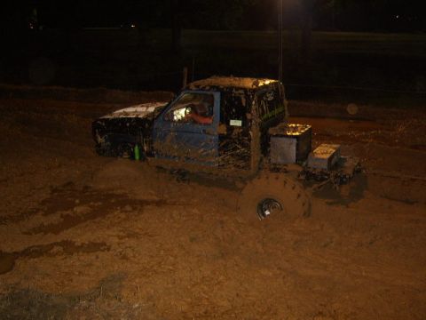 1986 Ford Ranger - A heavily muddied pickup truck is stuck in a muddy field at night.