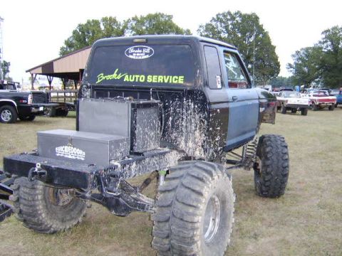 1986 Ford Ranger - This heavily modified 1986 Ford Ranger, covered in mud, features oversized tires and a custom "Brooks Auto Service" decal on the rear windo…