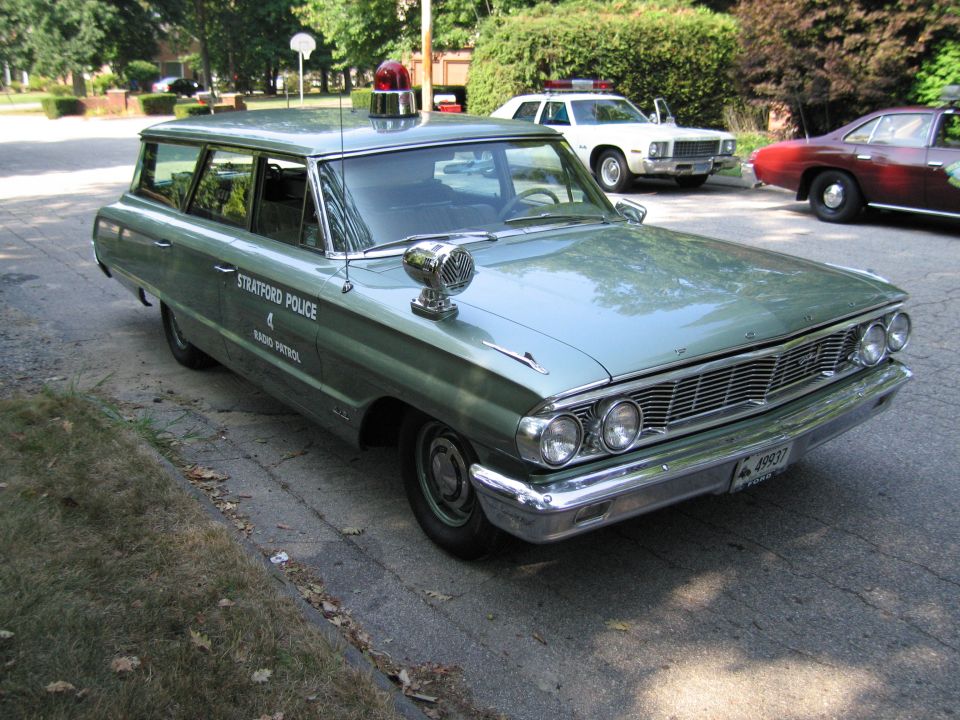 Green Stratford Police station wagon with roof beacon and hood siren on driveway