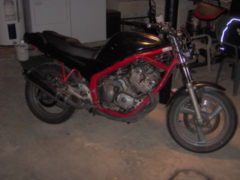 1993 Yamaha Seca II - A black motorcycle with a red frame is parked indoors, showing its engine and exhaust system.
