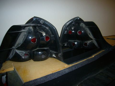 2000 Ford Crown Victoria - Two black car tail lights are shown from the rear, mounted on a wooden surface.