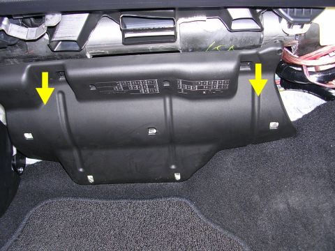2007 Mazda 3 - This image shows a black plastic fuse box cover inside a vehicle, with yellow arrows indicating attachment points.