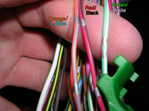 2007 Mazda 3 - A hand holds a bundle of electrical wires, some labeled with color combinations, suggesting a wiring harness or connection point of electri…