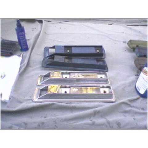1973 Ford Ranchero - Two car door trim pieces, possibly for a 1973 Ford Ranchero, are shown on a tarp with cleaning supplies.