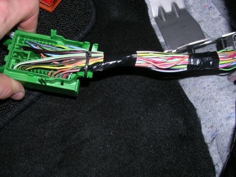 2007 Mazda 3 - A close-up view of a green wiring harness connector with multiple colored wires bundled together.
