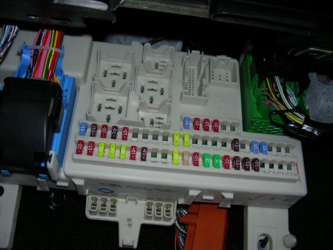 2007 Mazda 3 - Close-up view of a vehicle's interior fuse box, showing a variety of fuses and electrical connections.