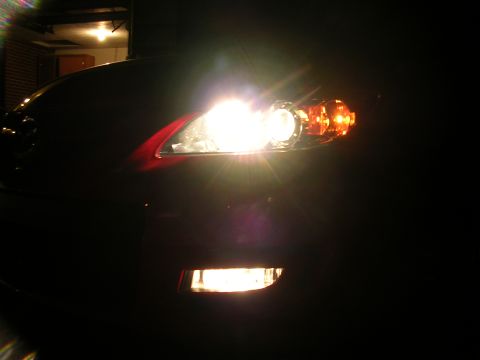 2007 Mazda 3 - The front fog lights and headlight of a 2007 Mazda 3 are illuminated at night.