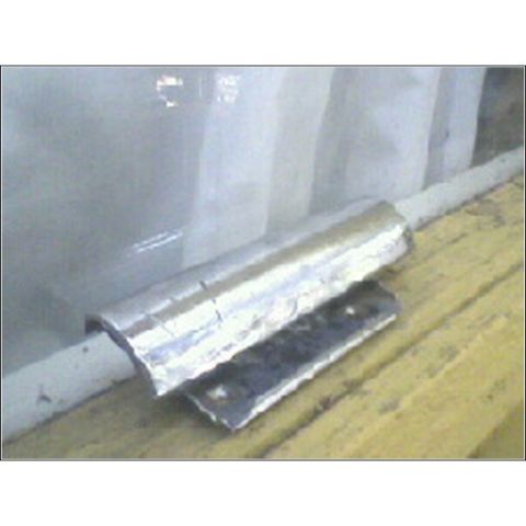 1973 Ford Ranchero - A close-up view of an exhaust pipe section covered by a reflective heat shield, mounted on a metal bracket.