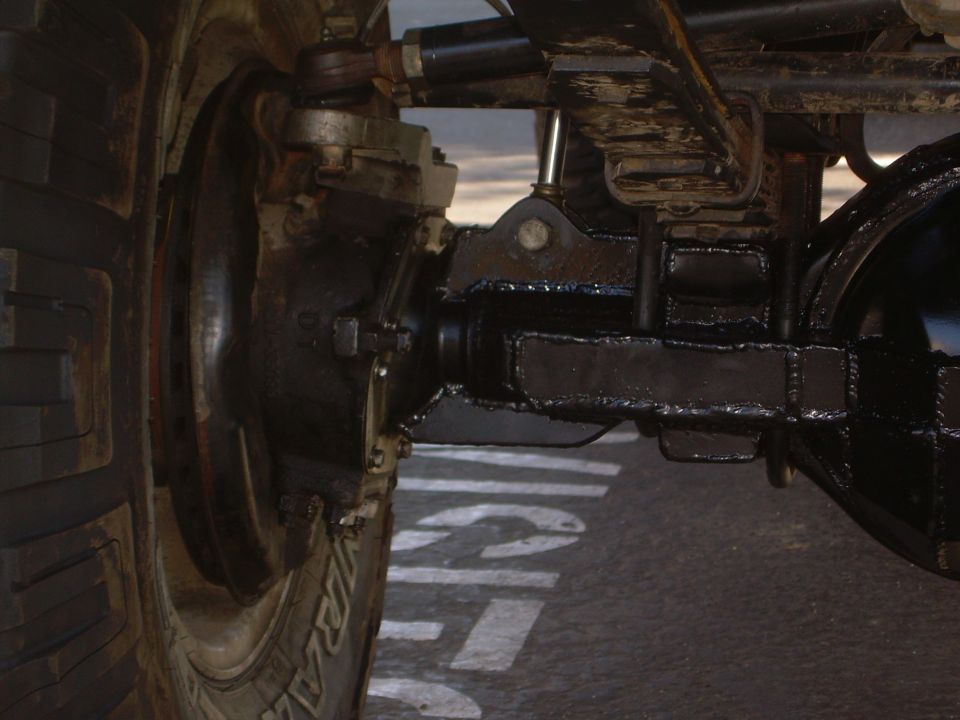 Rear axle assembly with leaf springs and a tire visible