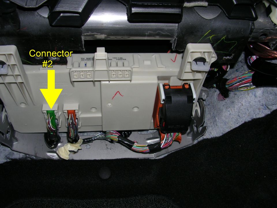 Vehicle interior wiring harness connectors labeled 'Connector #2' with a yellow arrow pointing to green and orange plugs