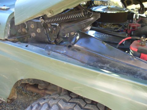 1978 Ford Bronco - The engine compartment of a vehicle is visible, with the hood open to reveal the engine and related parts.