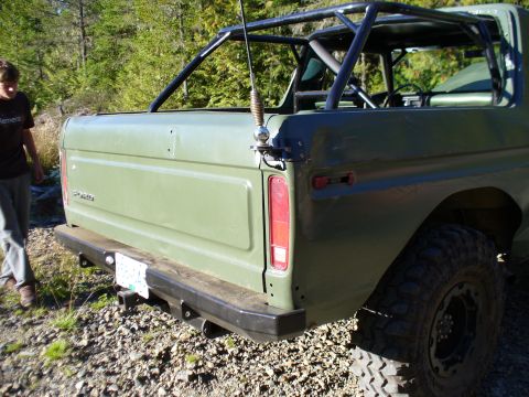1978 Ford Bronco - Rear view of a green 1978 Ford Bronco, equipped with a roll cage and off-road tires.