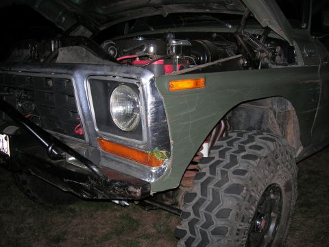 1978 Ford Bronco - Front view of a 1978 Ford Bronco with its hood up, revealing the engine bay and large off-road tires.