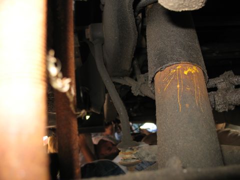 1995 Ford C-150 (Centurion Conversions) - Underside view of a vehicle's suspension system, showing heavily soiled and aged components.