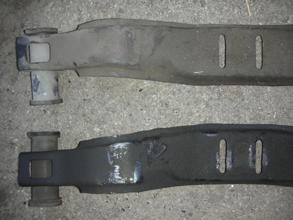 Two metal suspension parts, one above the other, with rubber bushings