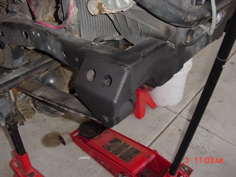 1992 Toyota Tacoma - Close-up view of a vehicle's frame and suspension components, supported by jack stands and a jack.