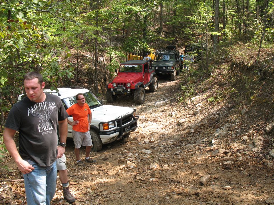 The party standing around waiting for the Rovers to climb a muddy little hill.