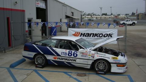1990 Ford Probe - A race car with its hood open, displaying Hankook sponsorship and the number 86 on its side.