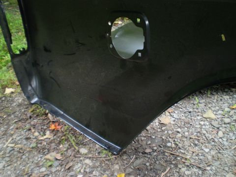 1979 Ford Bronco - Close-up of a black car fender showing the cutout for the fuel door.