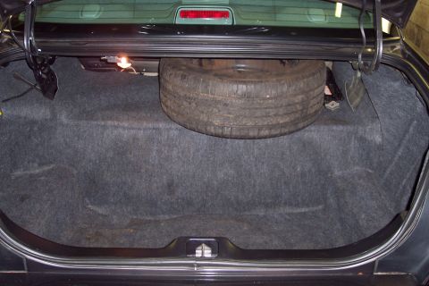 2001 Ford Crown Victoria - Trunk interior of a car, showing the spare tire and carpeting.