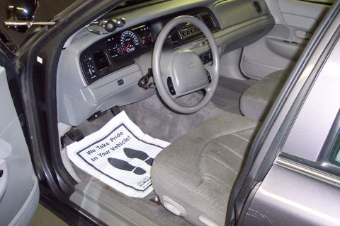 2001 Ford Crown Victoria - Interior view of a 2001 Ford Crown Victoria, a floor mat with footprints and a "We Take Pride In Your Vehicle!" message.