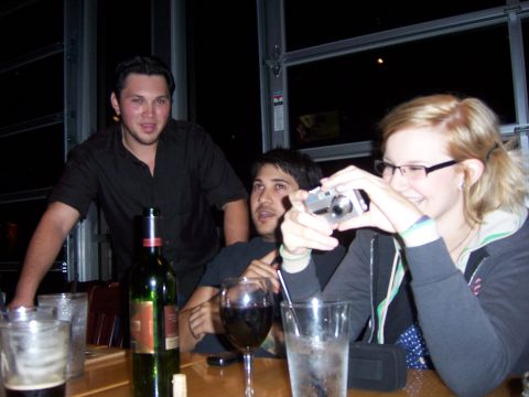 1991 Ford Bronco - Friends gather around a table with drinks, one person capturing the moment with a camera.