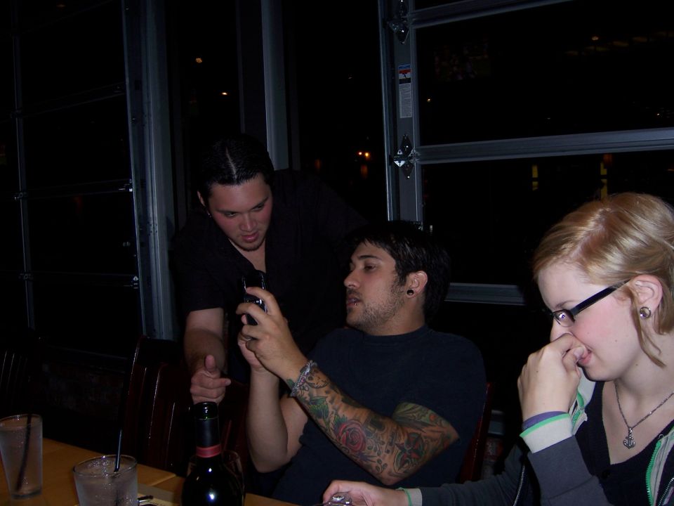 Three people gathered around a table indoors at night