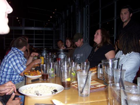 1991 Ford Bronco - A group of people are seated at a table, with drinks and plates of food in front of them.
