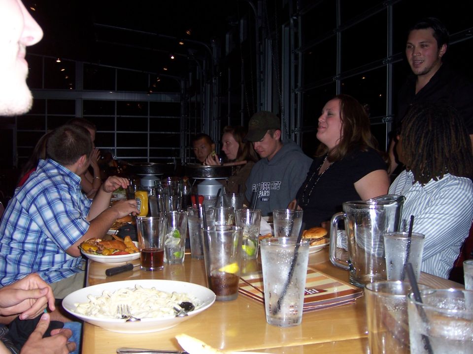 People gathered around a table with drinks and partially eaten food