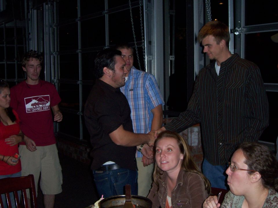 People gathered indoors, some talking and shaking hands