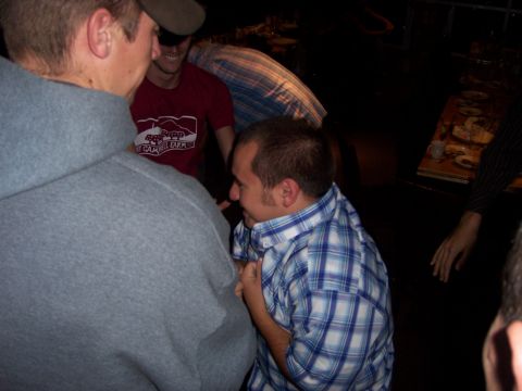 1991 Ford Bronco - A group of people are socializing indoors, with one man in a blue plaid shirt appearing to be the central figure.
