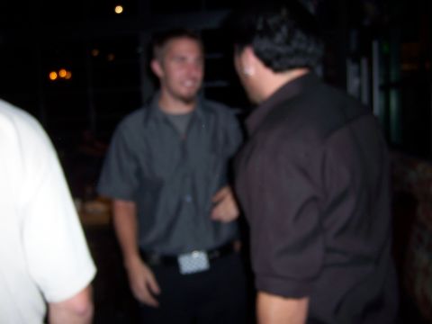 1991 Ford Bronco - Three men converse in a dimly lit indoor setting.