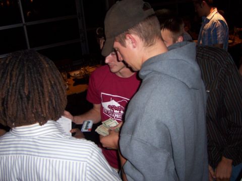 1991 Ford Bronco - A group of people are gathered, with one person holding a wad of cash and another looking at a card.