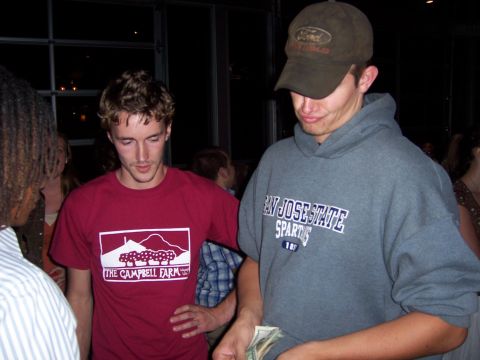 1991 Ford Bronco - Two men are seen at a party, one wearing a Ford baseball cap and the other a t-shirt with a farm logo.
